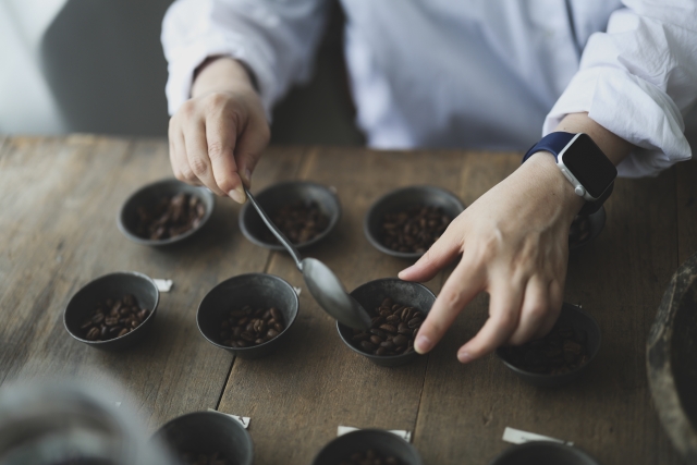 手でコーヒー豆を量る職人の様子